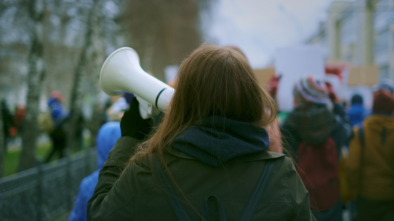 Young adult female activist feminist demonstration. Gender feminism fight resistance. Women march movement power sign equality. Strike empowerment action. Activist resistance. People city street day.