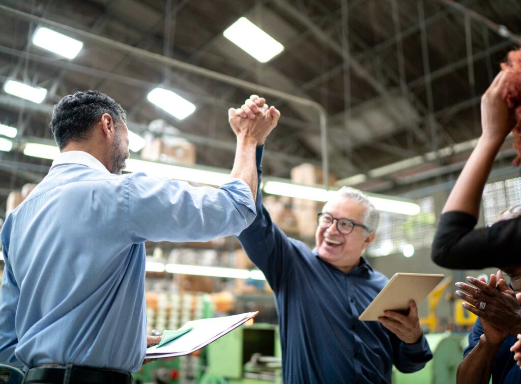 Coworkers celebrating some good news in a factory