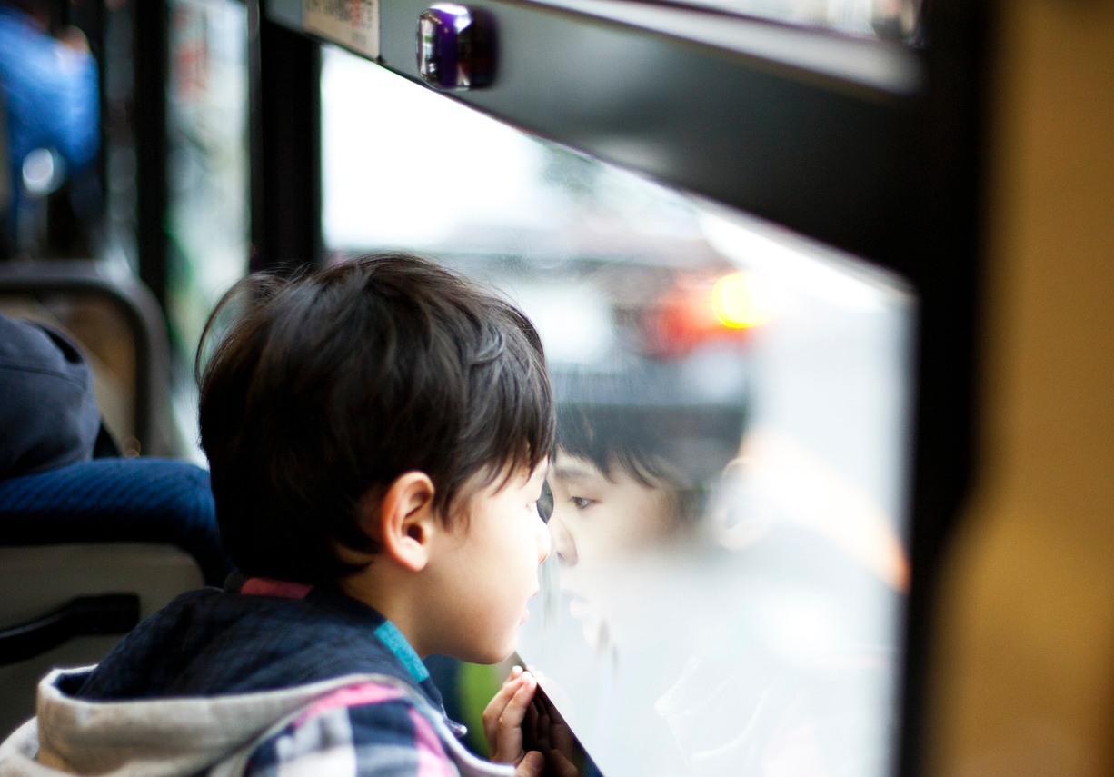 Boy looking out of the window of a bus. Tokyo, Japan