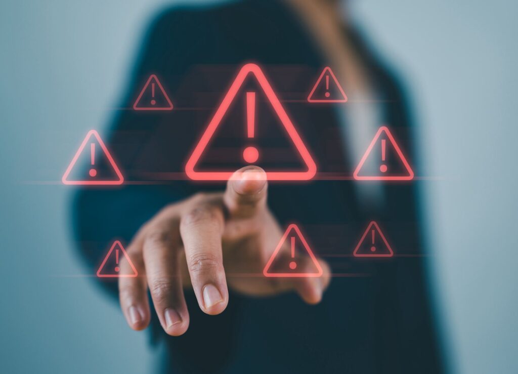 Businessman touching virtual warning sign for caution in investing economic situation warning, Business investment risks.