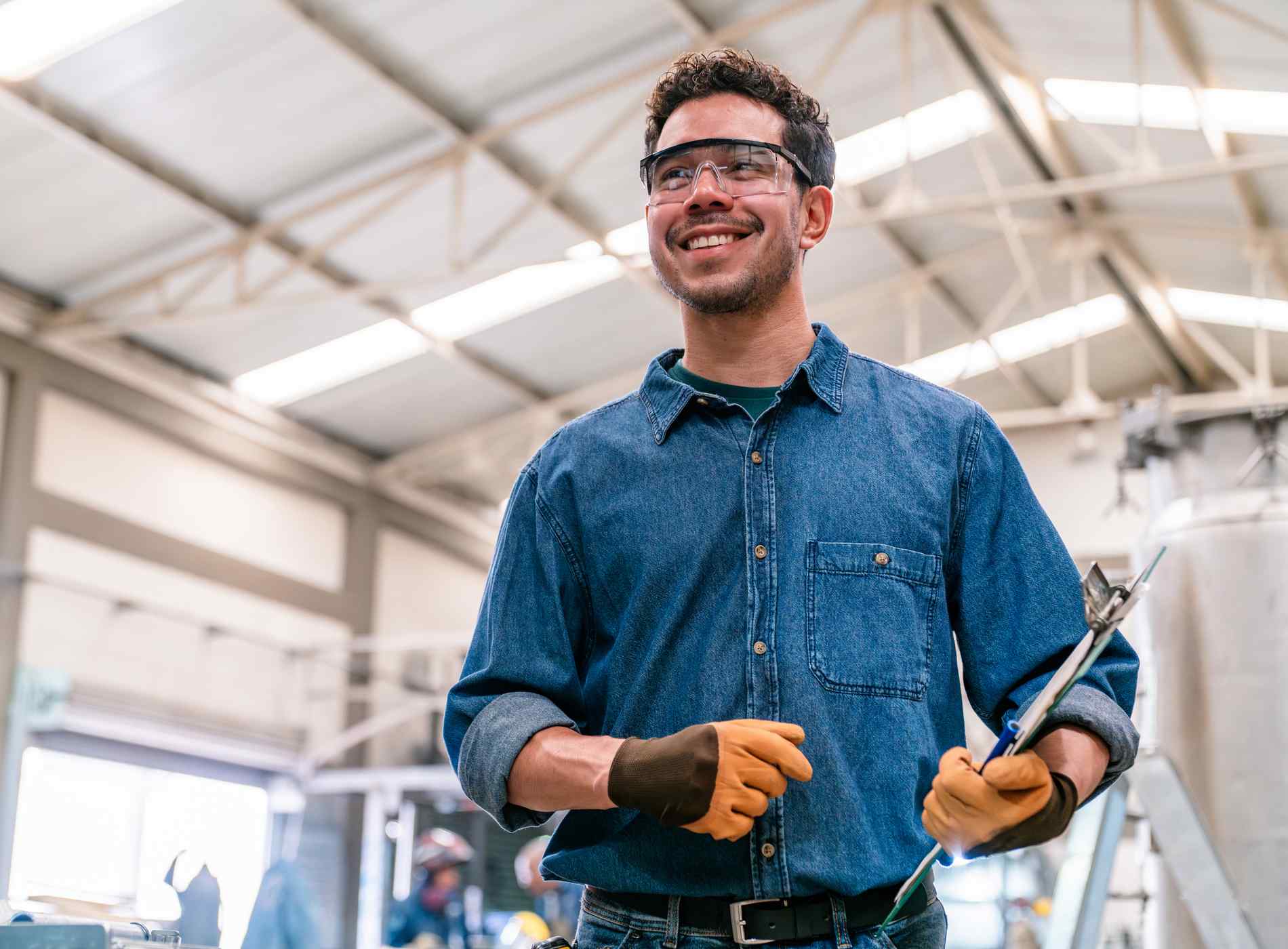 Portrait of a happy Latin American supervisor working at a metallurgy factory and smiling