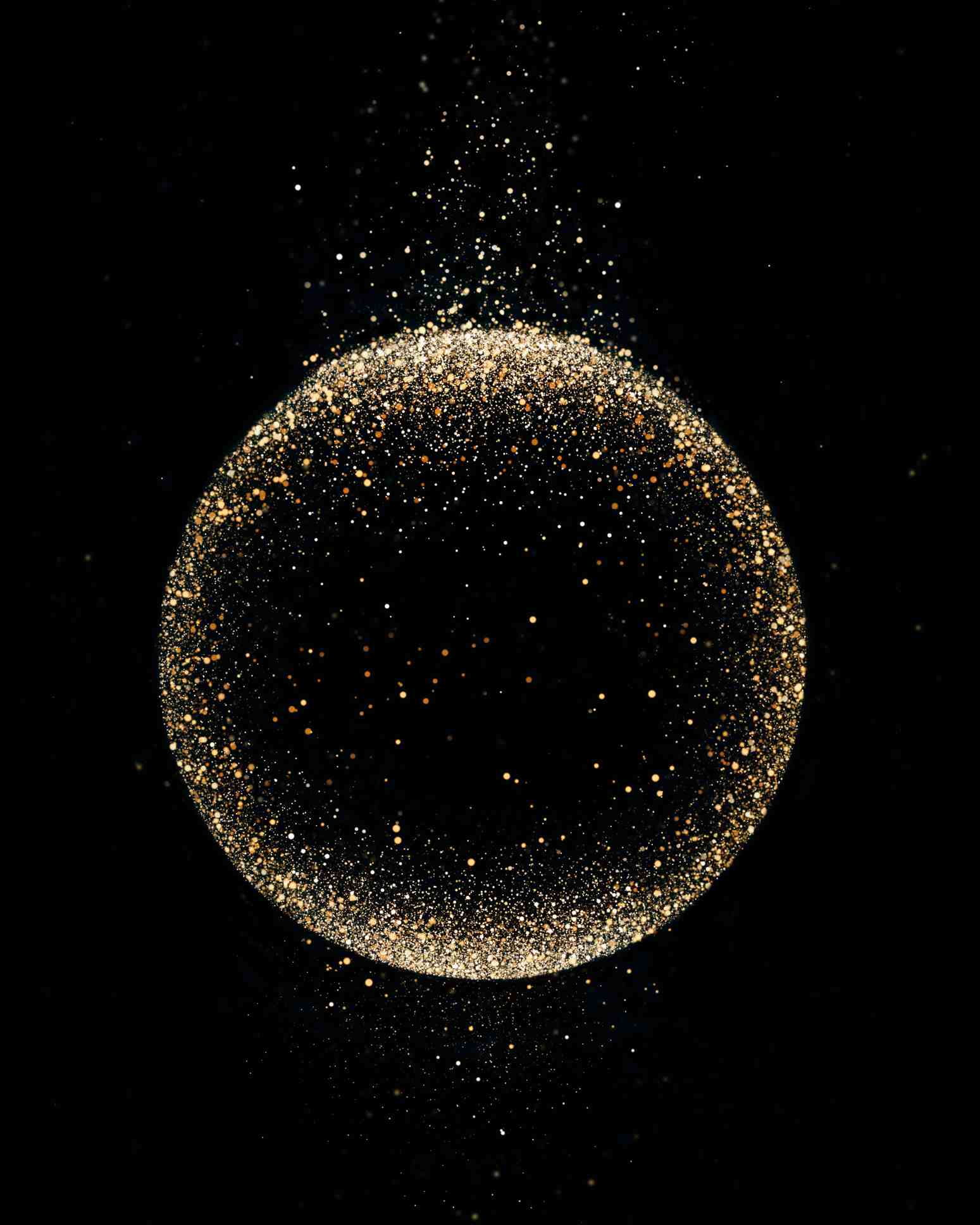 Golden sparks form a circle over black background.
