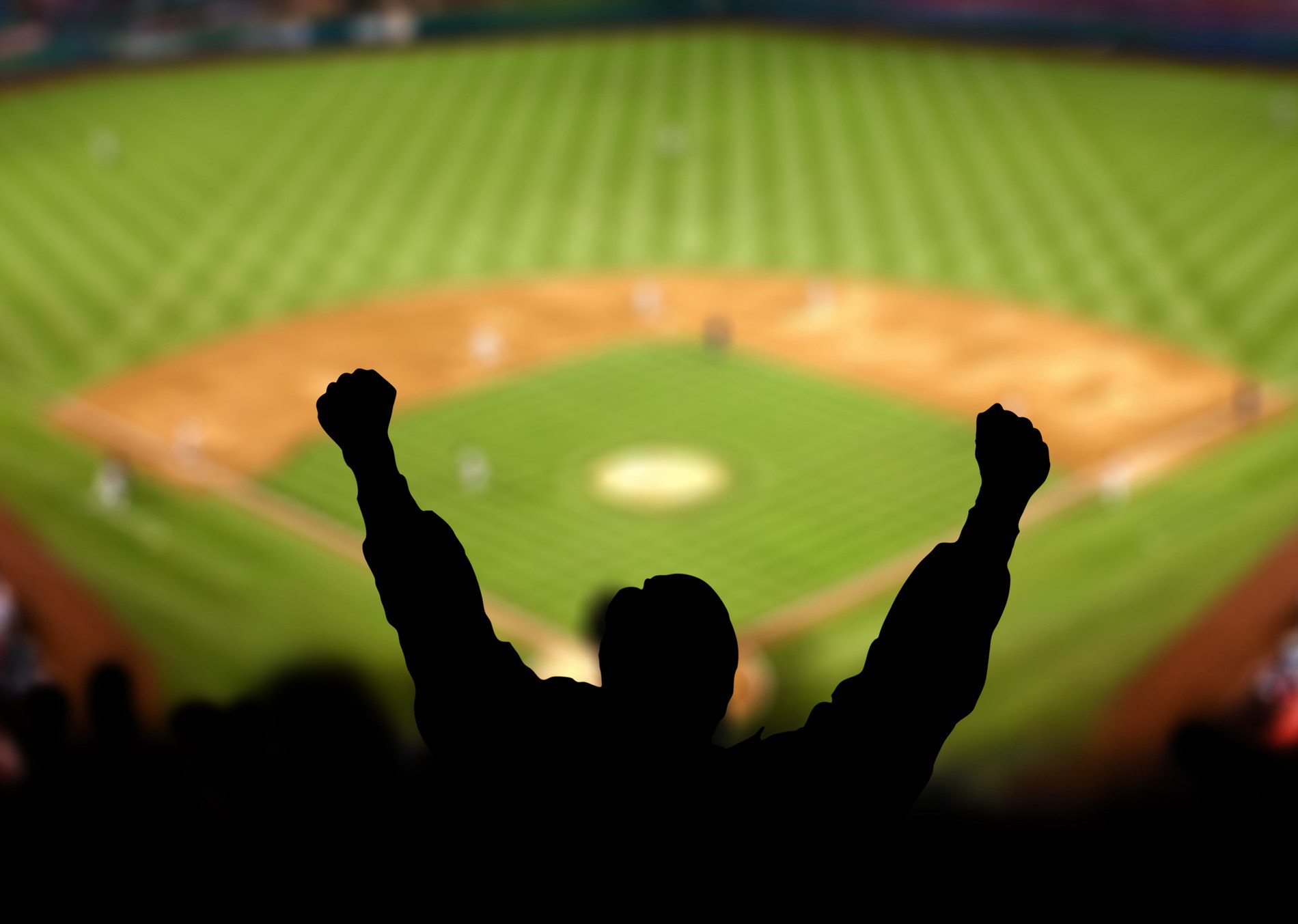 Fans lifting hands in celebration at a baseball game