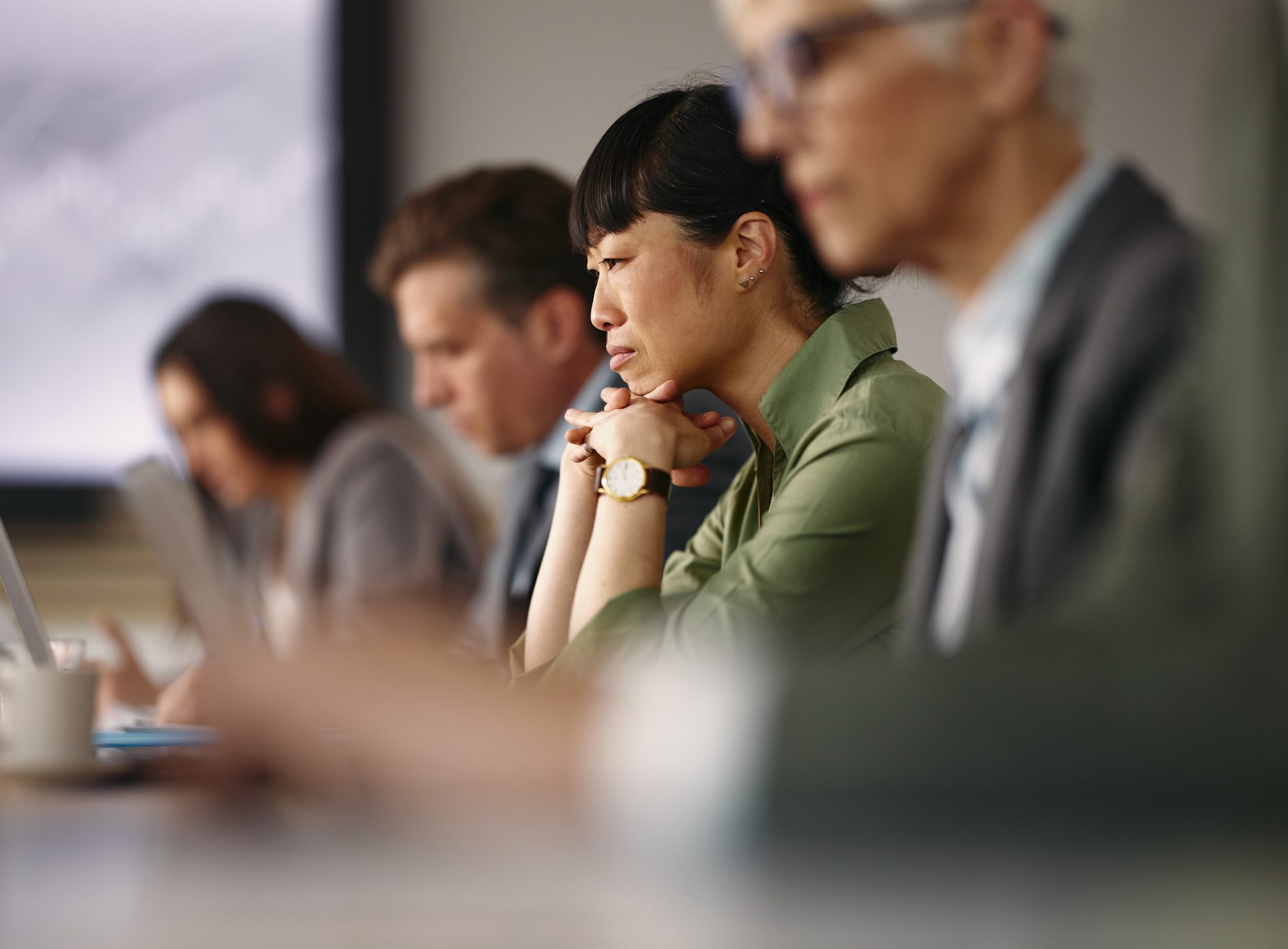 Japanese female entrepreneur brainstorming while working on a computer among her colleagues on a meeting in the office.