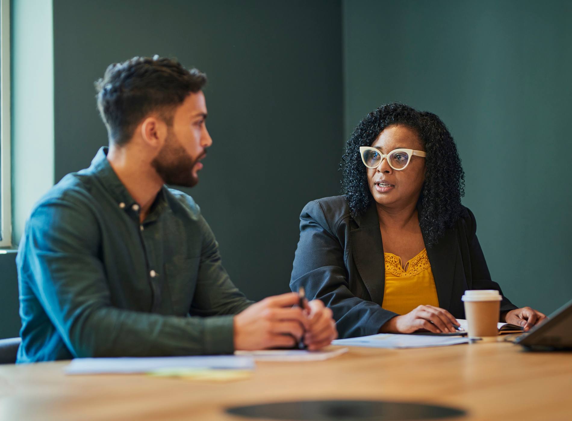 Business professionals in a meeting room discussing ideas and strategies.