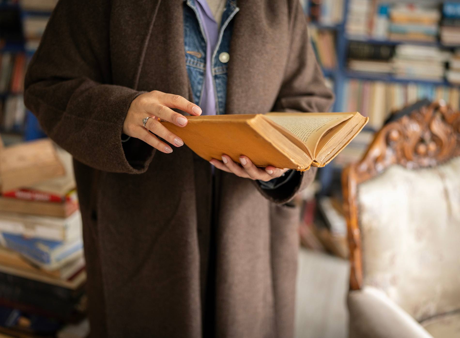 Close up of a woman holding and reading an old hardcover book. Concept of education, knowledge, literature and lifelong learning