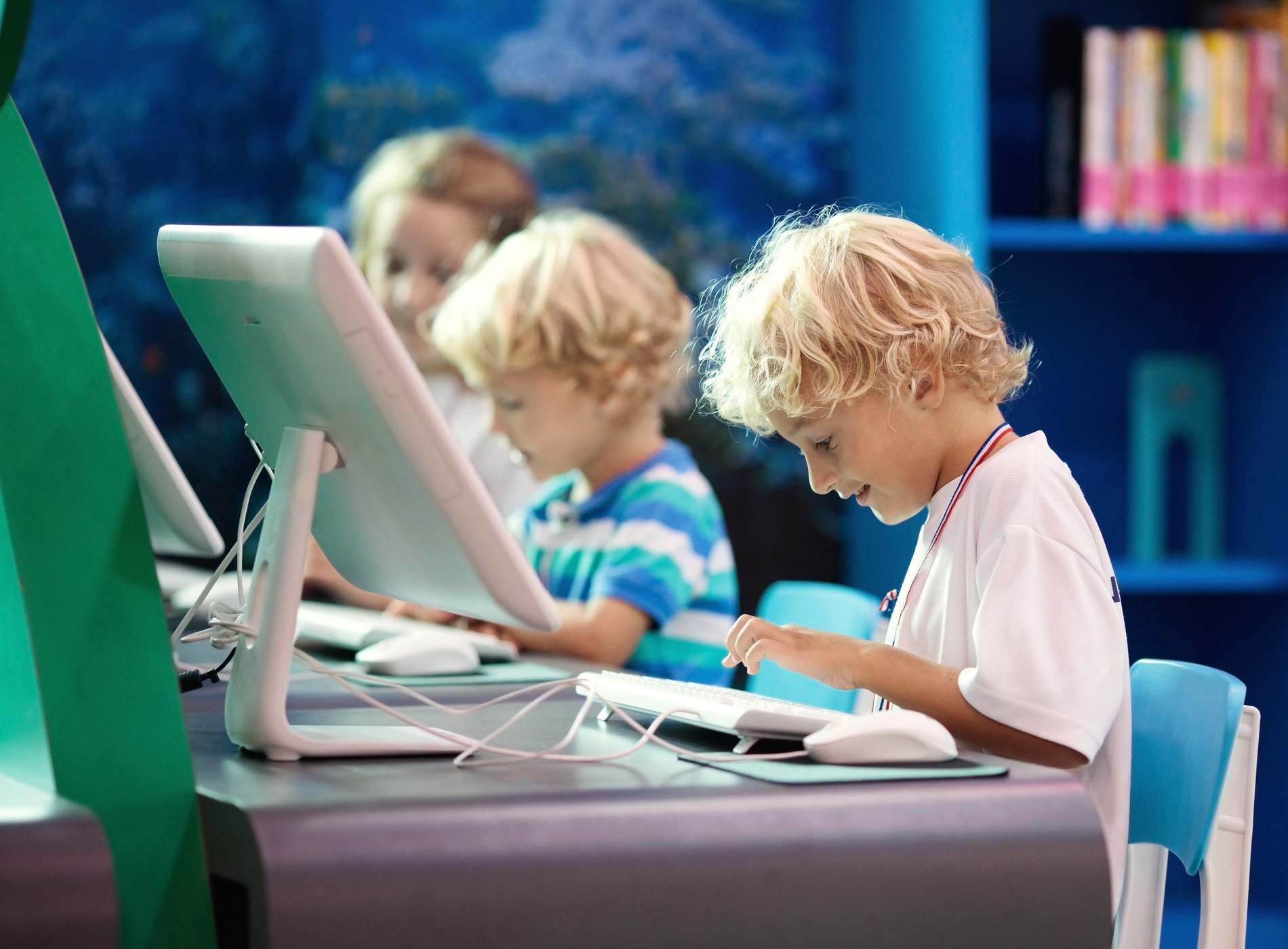 Kids with computer. Children learning and studying information and communications technology using personal computers in school class or library. Student at pc. Modern education device for child.