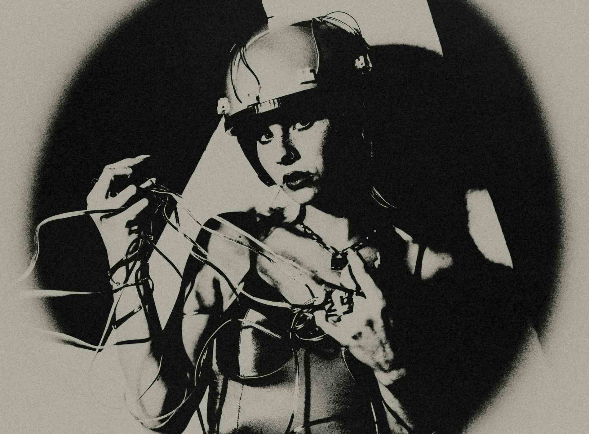 Portrait of young beautiful woman wearing electric wired helmet. She holds her wiring in her hand. Ready for the exciting club scene.