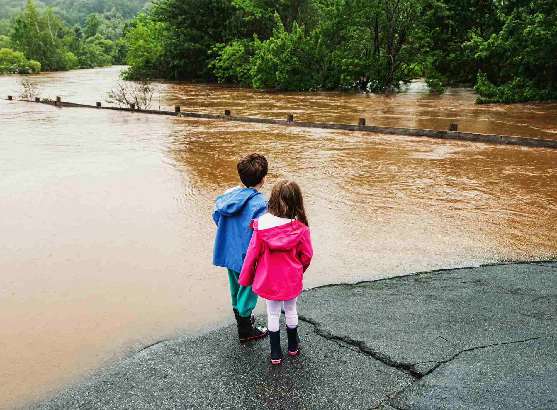 Brother and sister look at flood damage after record-setting rainfall.